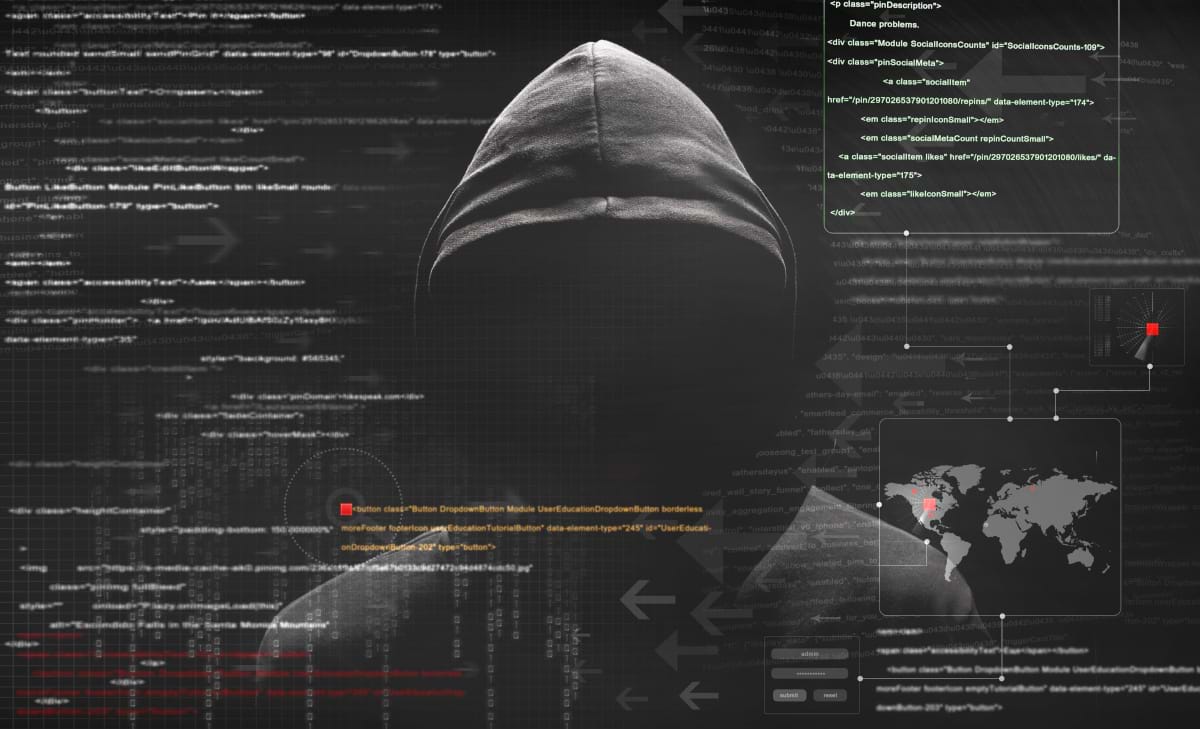 A man with his face concealed by a black pulled up hoodie, looking at all the data displayed in front of him.